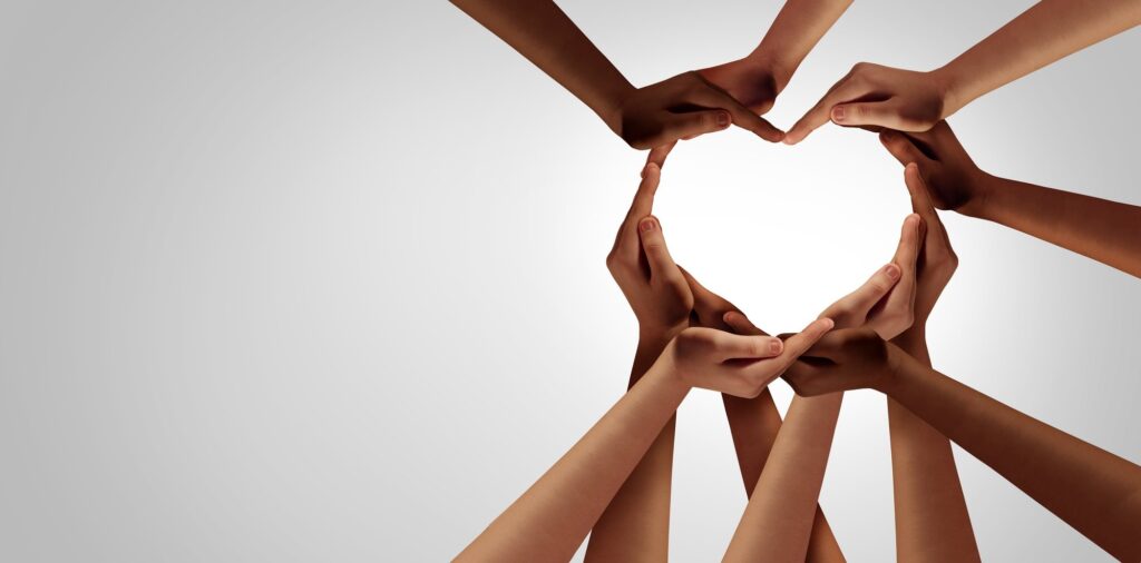 10 forearms and hands coming together from all angles to make a heart shape.